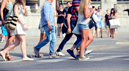 Sunlit summer pedestrians on zebra crossing