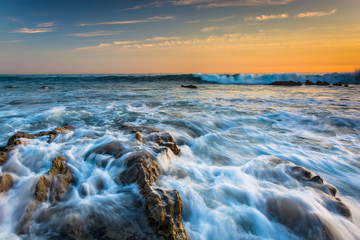 Fototapeta premium Rocks and waves in the Pacific Ocean at sunset, in Corona del Ma