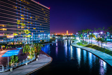 View of a modern building and Rainbow Lagoon Park at night, in L