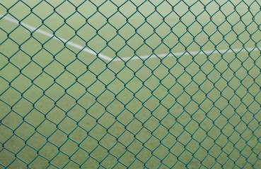 Fototapeta premium Sport field with grass behind security grid