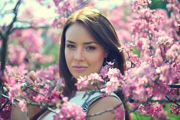 Naklejka premium girl in flowers of apple tree