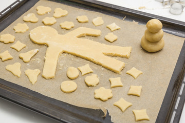 Ausgestochene Plätzchen und Mann auf Backpapier