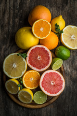 Obraz na płótnie Canvas Halves of citrus fruits on wooden background. Orange, grapefruit