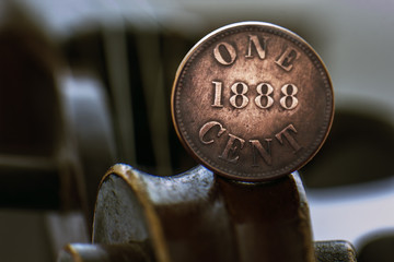 Old one cent coin on a violin scroll