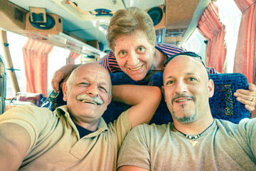 Senior happy couple with son taking a selfie during a bus trip © Mirko Vitali
