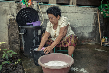 Senior asian woman washing cloths by hand