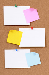 Several three office index or file card pinned to cork bulletin board background with post it...
