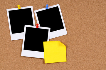 Several three polaroid style blank photo frame prints with sticky note pinned to cork notice board background