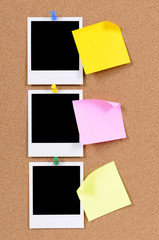 Fototapeta premium Vertical row or line of polaroid style blank photo frame print with post it sticky note pinned to cork notice board background