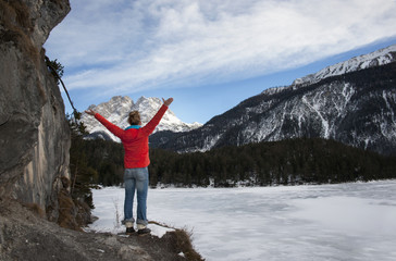 Woman standing by a frozen lake with Zugspitz