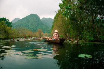 Girl in traditional costumer rowing boat