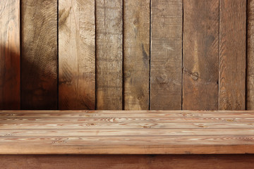 пустой деревянный стол на фоне стены из досок