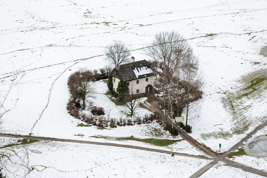 Aerial view on lonely house in field covered by snow at Salzburg
