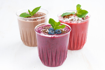 blueberry, chocolate and strawberry milkshakes in glasses