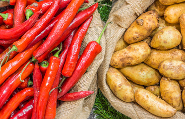 Harvest potatoes in burlap sack on rustic background