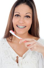 Attractive young woman with brackets cleaning her teeth