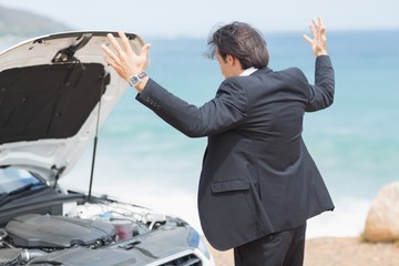 Anger businessman looking at engine