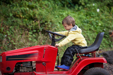 Adorable little boy, pretending to ride a lawn mower