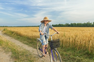 Fototapeta na wymiar Teenager boy riding a bicycle on country road