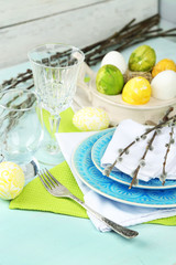 Easter table setting on color wooden background