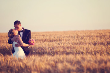 bride and groom enjoying wedding day in the fields