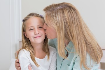 Happy mother kissing her little girl