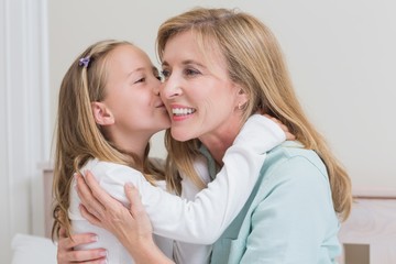 Cute little girl kissing her mother