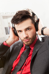 Mann im Anzug hört Musik mit Kopfhörern