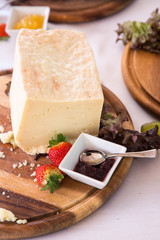 Formaggio fresco e marmellata su piatto in legno
