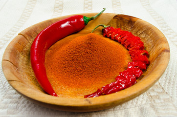 Two chili peppers and chili powder - obrazy, fototapety, plakaty