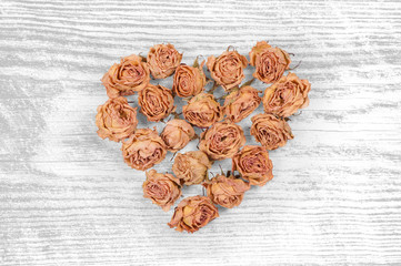 dry rose flowers heart isolated on white wooden panel