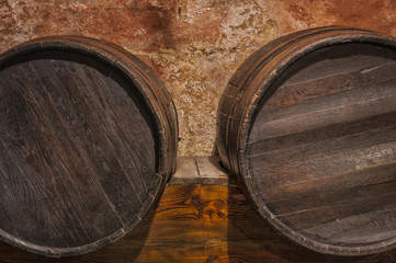 Wine cask barrels stacked in the old cellar of the winery