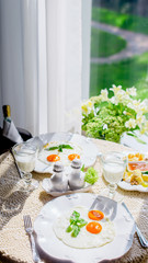 breakfast in front of sunny window eggs cheeses and kefir