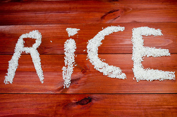 Rice text on wooden table - obrazy, fototapety, plakaty