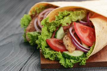 pair of fresh juicy tortilla wraps with chicken and vegetables