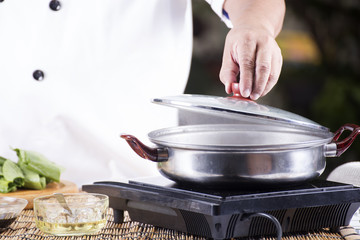 Chef opening the lid of pot before cooking noodle