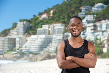 Happy young man smiling at the beach