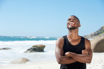 Happy young man laughing at the beach