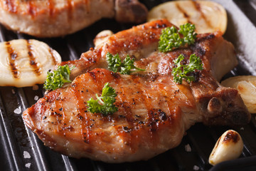 Juicy pork steak grilled with onions in a pan grill closeup