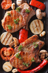 Grilled steak with vegetables on grill macro. Vertical top view