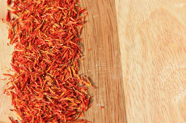 heap of saffron spice on wooden plank background