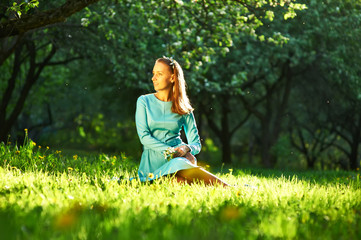 Woman in dress among apple blossoms