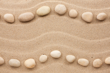 Fototapeta na wymiar Two rows of white stones on the sand
