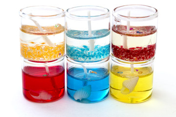 candles in glass in a row on top of each other on a white