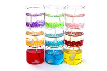 candles in glass in a row on top of each other on a white