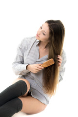 Gorgeous model combing her hair in shirt and spats