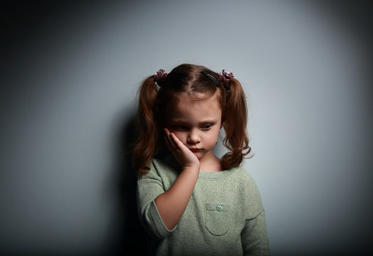 Sad alone kid girl thinking on dark. Problems at family