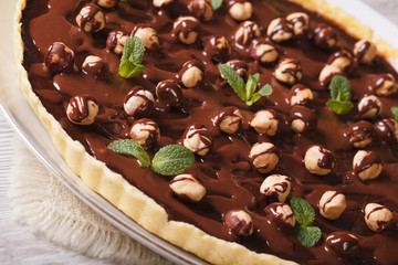 tart with chocolate and hazelnuts on a table closeup. Horizontal