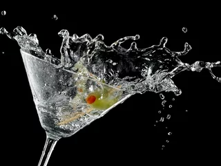 Tuinposter Cocktail with a olive splash on black background © Mariyana M