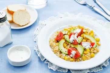 salad with quinoa, red lentils, corn, avocado and tomato with yo